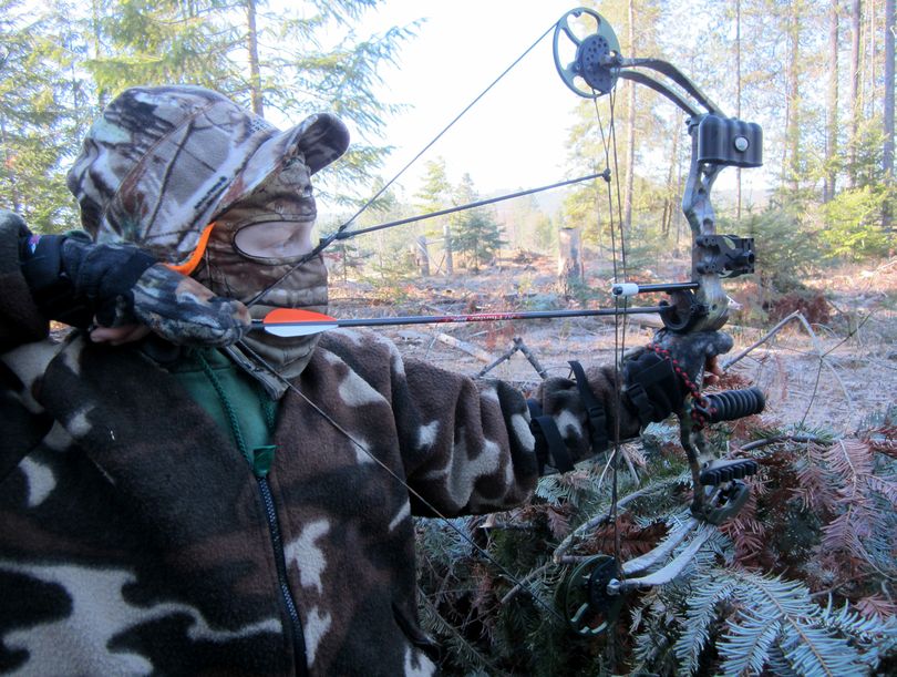 Carsen Smith draws his bow on a father- son outing during the Washington wild turkey hunting season in 2013. (Courtesy Photo / The Spokesman-Review)