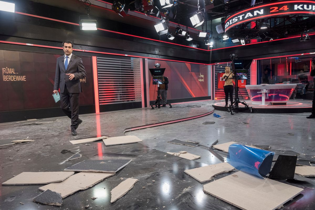 Employees of Kurdistan 24, a satellite television station, work in a studio damaged by an Iranian ballistic missile attack in Irbil, Iraq, Sunday, March 23, 2022. (Ahmed Mzoori)