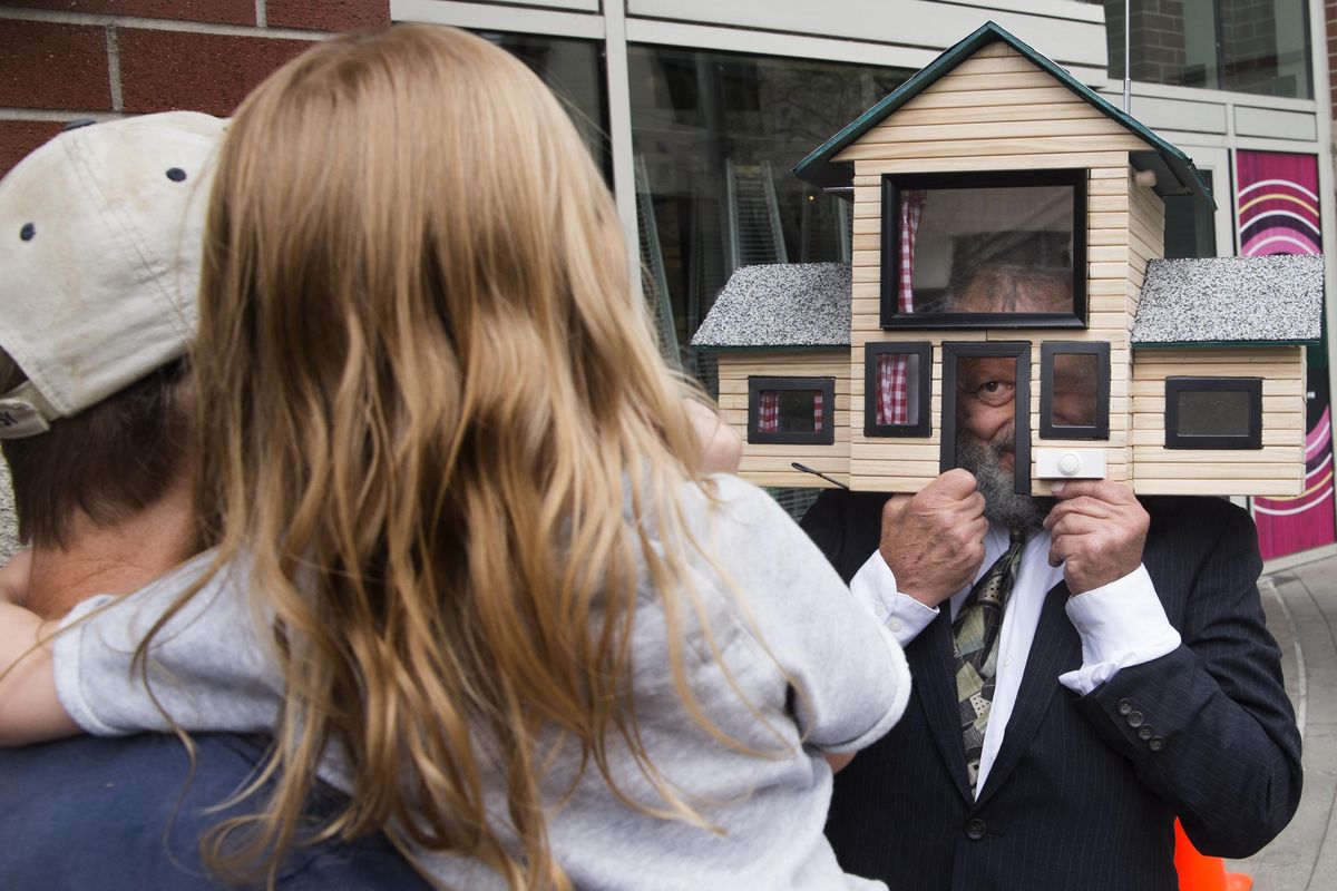 Charlie Schmidt, a Spokane performance artist and Keyboard Cat inventor, demonstrates his latest gag, “the Head Suite” to youngster Etty Jane Cramer, 3, and her grandfather Mark Cramer on Tuesday, Aug. 30, 2016, in downtown Spokane, Wash. The house is a spoof of the tiny house movement. (TYLER TJOMSLAND tylert@spokesman.com / SR)