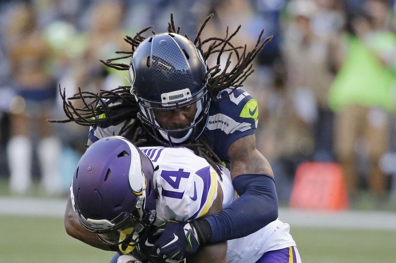 Seahawks cornerback Richard Sherman tackles Vikings wide receiver Stefon Diggs. (Elaine Thompson / Associated Press)