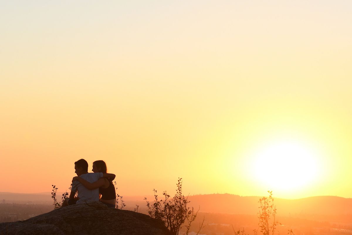 A young couple, who preferred to remain anonymous, watch the sunset Thursday from a high point in the Saltese Uplands Conservation Area southeast of Spokane Valley.  (Colin Tiernan/The Spokesman-Review)