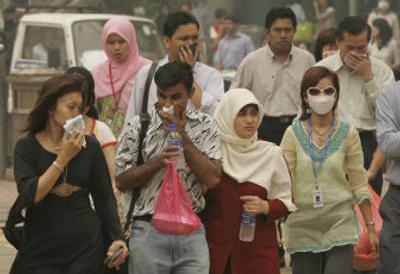
Pedestrians cover their faces with handkerchiefs Thursday to aid breathing in the dense haze that blanketed downtown Kuala Lumpur.
 (Associated Press / The Spokesman-Review)