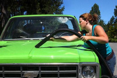
Brooke Lloyd vacuums glass off her Chevy in Spokane Valley on Friday. Lloyd's was one of eight vandalized vehicles reported to police Thursday morning. 
 (Liz Kishimoto / The Spokesman-Review)
