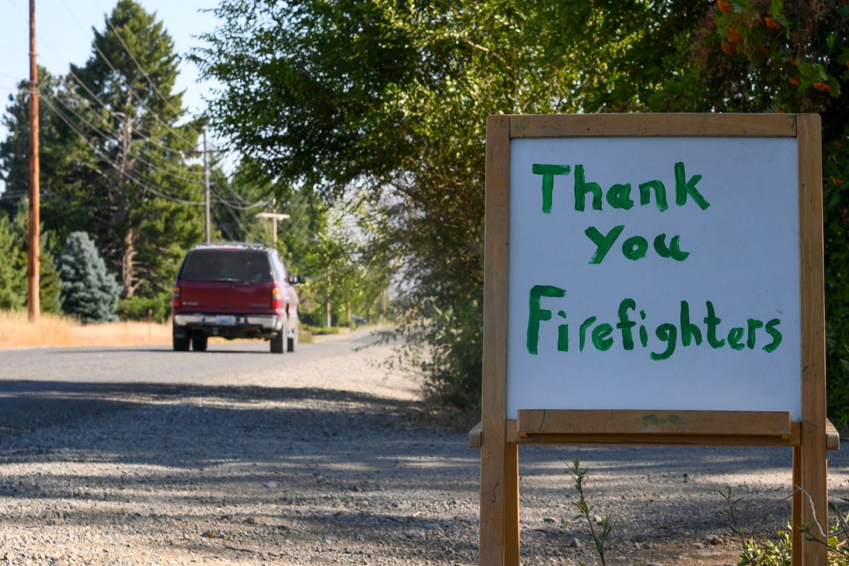A whiteboard sign along Greenacres Road in Omak, Washington reads "Thank You Firefighters." (Bonny Matejowsky / The Spokesman-Review)