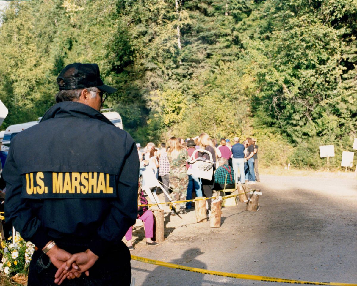 A U.S. marshal monitors a roadblock down the mountain from the Weaver cabin. (“American Experience: Ruby Ridge” photos/PBS)