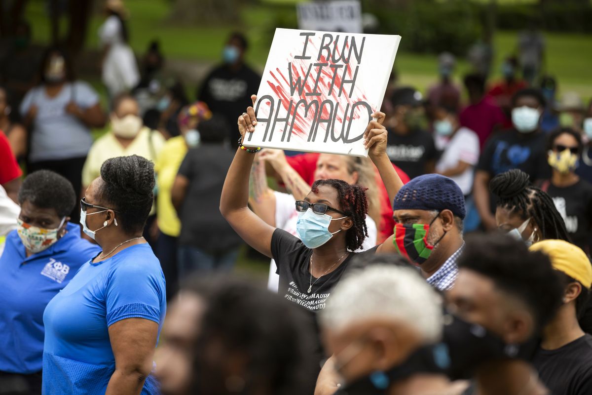 In this May 16, 2020 photo, a woman holds a sign during a rally to protest the shooting of Ahmaud Arbery, in Brunswick, Ga. Arbery was shot and killed while running in a neighborhood outside the port city. Jury selection in the case is scheduled to begin Monday, Oct. 18.  (Stephen B. Morton)