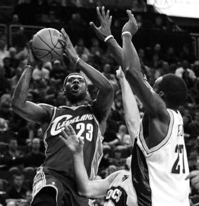 
Cleveland's LeBron James looks to score over the long arms of Seattle's Johan Petro during first-quarter play.
 (Associated Press / The Spokesman-Review)