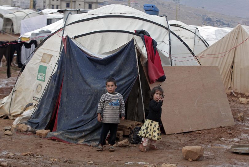 Syrian children stand near their tent at a refugee camp in the eastern Lebanese border town of Arsal, Lebanon, Monday, Nov. 18, 2013. Thousands of Syrians have fled to Lebanon over the past days as government forces attack the western town of Qarah near the border with Lebanon. (Bilal Hussein / Associated Press)