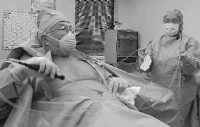 
Dr. Robert Ersek performs liposuction on himself as members of the press gather in the operating room to witness the event Thursday in Austin, Texas. 
 (Associated Press / The Spokesman-Review)