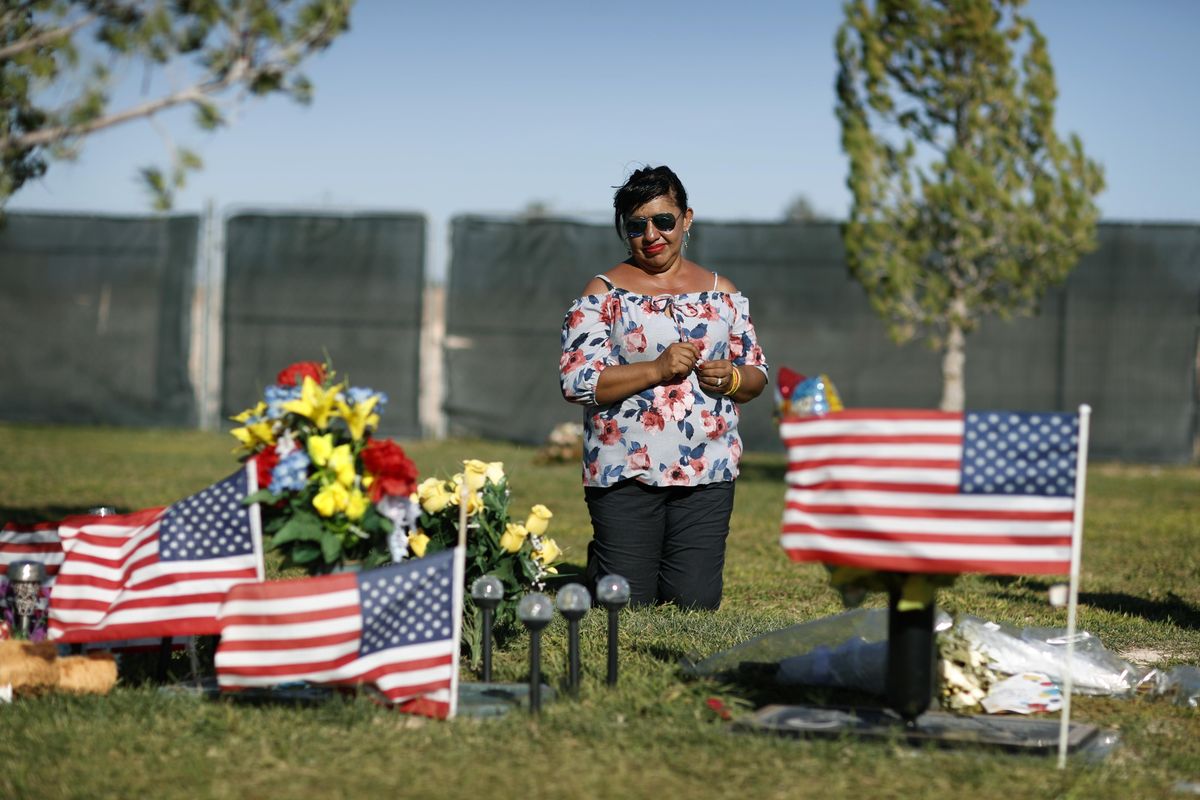 Angelica Cervantes kneels at her son Erick Silva’s grave Saturday, Sept. 29, 2018, in Las Vegas. (John Locher / Associated Press)