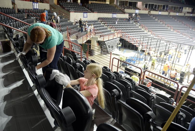 Volunteer Ellie Labrucherie, 8, and her mother Amanda, left, wipe down seats in the Spokane Arena Thursday, June 30, 2016. Volunteers from local Jehovah's Witness congregations will scrub and scrape around every seat and walkway of the Spokane Arena before their three-day convention. Church officials say that the church likes to leave their meeting spaces in better condition than when they arrived. More than 50 JW congregations will assemble for a three-day meeting July 1-3 at the Arena, a group estimated to be 6200 people. The evangelical group also invites everyone who would like to know more about their beliefs to attend also. There will be two sessions, morning and afternoon, each day. (Jesse Tinsley/SR photo)