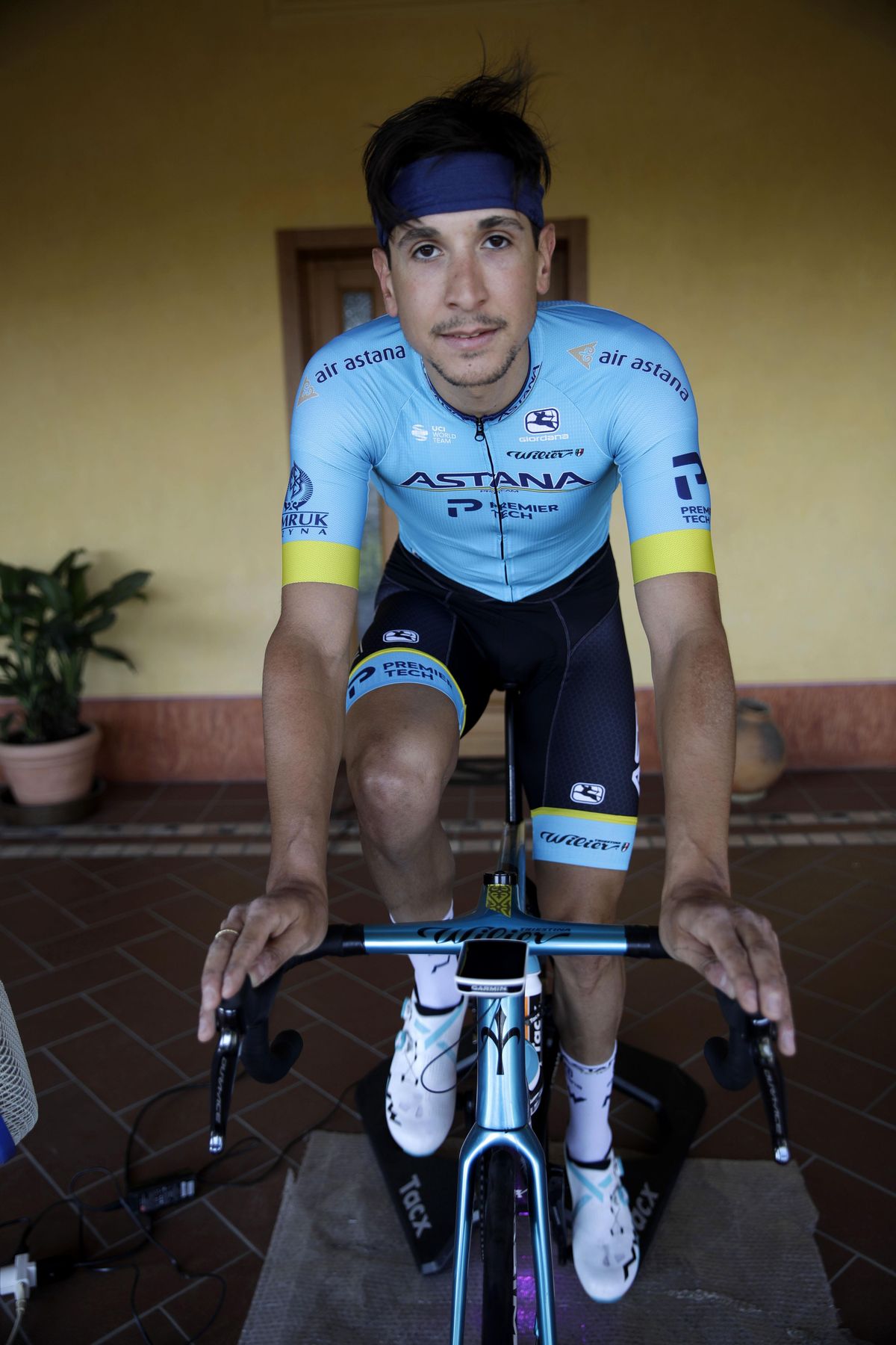 In this image taken on Tuesday, April 14, 2020, Italian professional cyclist Davide Martinelli, trains at home in Lodetto, near Brescia, Northern Italy. There are no fans lining the road. No teammates providing support. And no race to win. Professional cyclist Davide Martinelli has achieved a moral victory, though, by using his bike to help deliver medicine to elderly residents of his hometown in northern Italy during the coronavirus pandemic. (Luca Bruno / Associated Press)