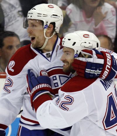 Montreal’s Travis Moen, left, celebrates with Dominic Moore after scoring a second-period goal against Pittsburgh on Wednesday.  (Associated Press)