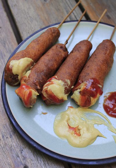 Pair these traditional Iowa State Fair-style corn dogs with ketchup or mustard or both – and, on a hot summer day, maybe a cold, crisp, effervescent beer. (Adriana Janovich)