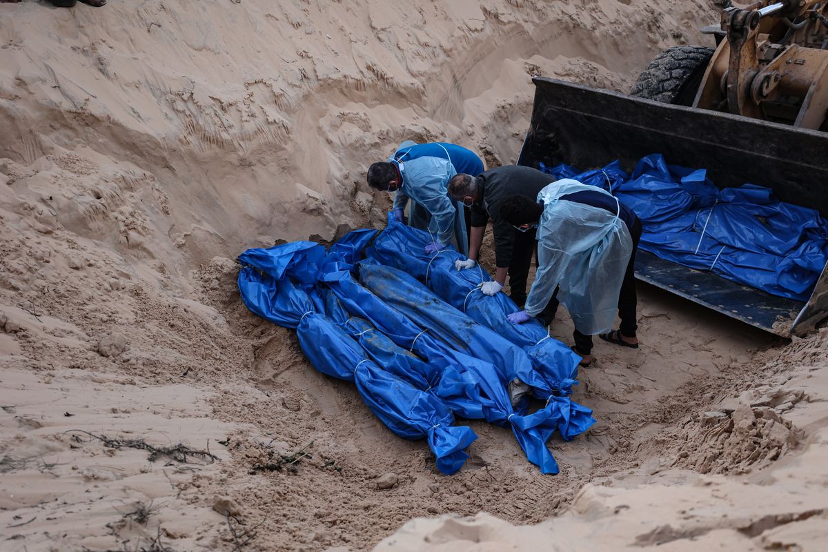 People bury 80 Palestinians in a mass grave after their bodies were returned by Israeli forces Tuesday. MUST CREDIT: Loay Ayyoub for The Washington Post  (Loay Ayyoub/For The Washington Post)