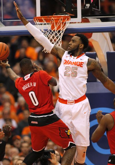 Syracuse’s Rakeem Christmas, right, blocks a shot by Louisville’s Terry Rozier. Syracuse upset the 12th-ranked Cardinals 69-59. (Associated Press)