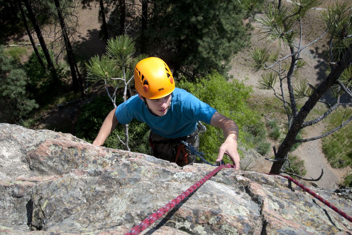 Calvin Van Wert, 14, reaches the top of his climb at Shields Park (Minnehaha Rocks) during an outing with Exploring Families on May 16 in Spokane. (Dan Pelle)