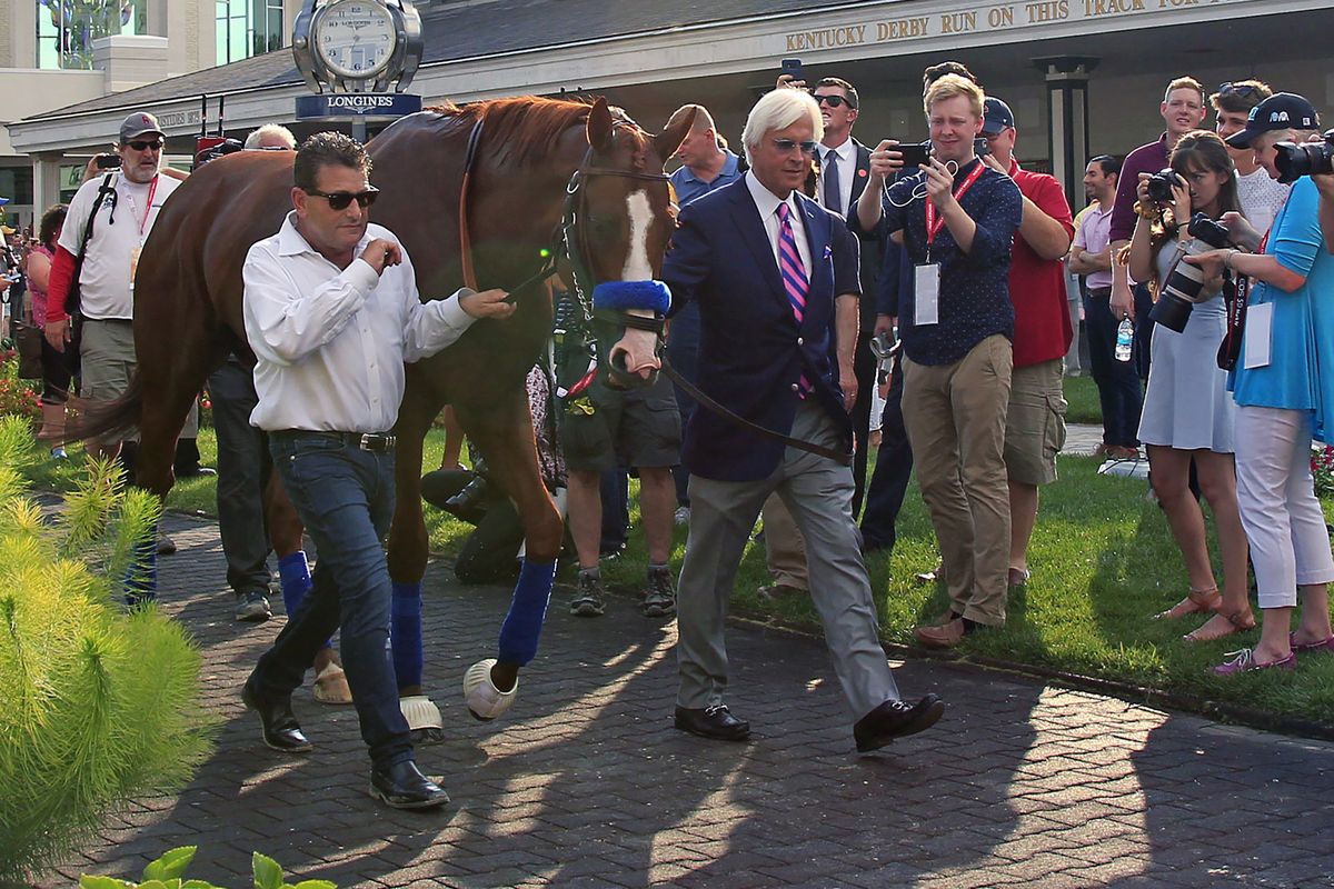 In this June 16, 2018 photo, trainer Bob Baffert, right, and assistant Jimmy Barnes, left, lead Triple Crown winner Justify around the paddock at Churchill Downs in Louisville, Ky. Baffert is undefeated taking the Kentucky Derby winner to the Preakness, but for the first time in 20 years he’ll do so without assistant trainer Jimmy Barnes, who broke his right wrist in a paddock accident at Churchill Downs.  (Garry Jones)