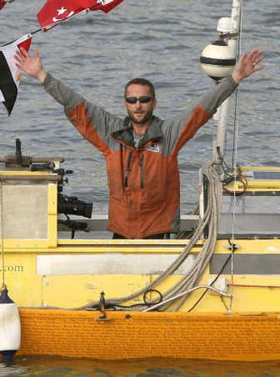 
Jason Lewis waves Saturday from the Thames River in Greenwich, London, where his expedition began in 1994. Associated Press
 (Associated Press / The Spokesman-Review)