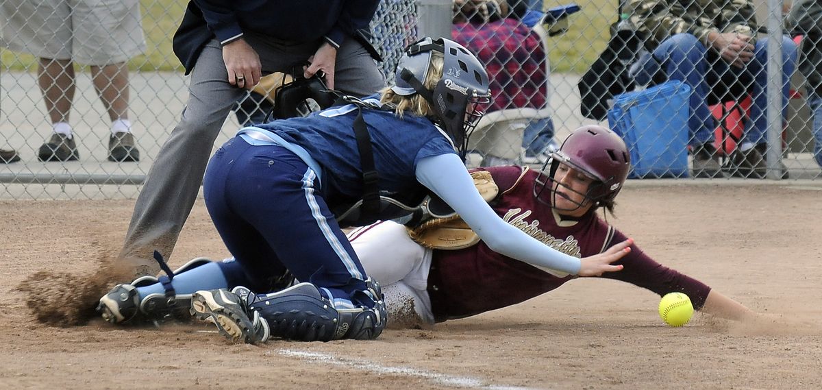 University’s Katelin Lewis slides under Central Valley catcher Jessica Smith during the fourth inning Thursday to score the Titans’ fifth run.  (Dan Pelle / The Spokesman-Review)