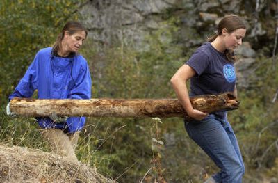 
Teena Carnegie, left, and LaNae Fisk, both from Spokane, carry a log for use as a trail barrier while volunteering their time during Adopt-a-Crag, a North Idaho College Outdoor Pursuits park maintenance and cleanup day at Q'emiln Park in Post Falls Saturday. 
 (Tom Davenport/ / The Spokesman-Review)