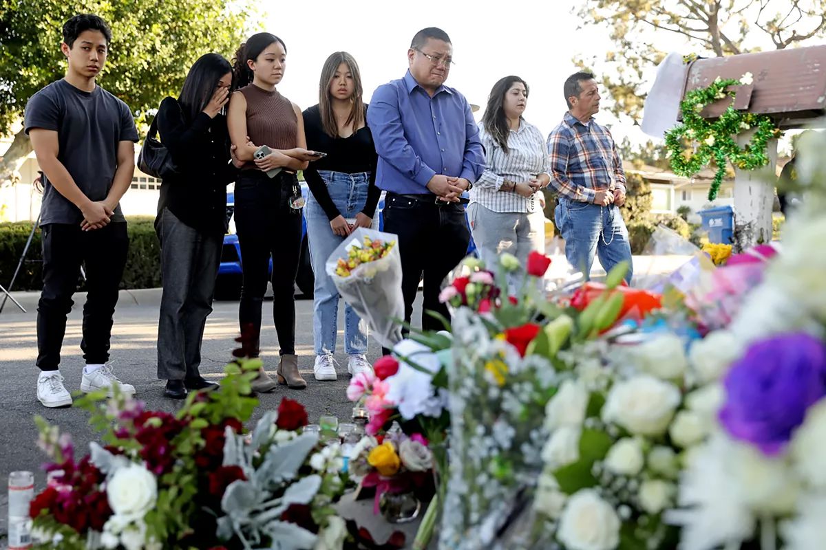 The Hui family of Arcadia join other mourners to hold a vigil outside the home of Bishop David O'Connell in Hacienda Heights.    (Gary Coronado/Los Angeles Times/TNS)