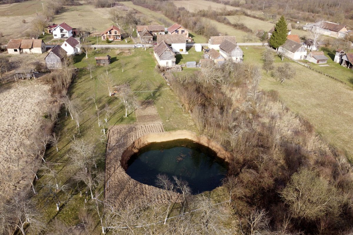 This aerial photo shows a sinkhole in the village of Mecencani, central Croatia, Thursday, March 4, 2021. A central Croatian region about 25 miles southwest of the capital Zagreb is pocked with round holes of all sizes, which appeared after December