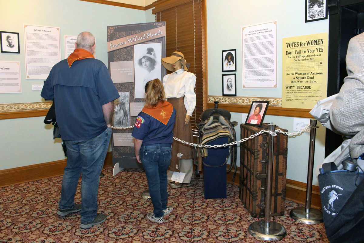Visitors to the Arizona Capitol Museum look at a display honoring the state’s early suffrage movement on March 11 in Phoenix. (Bob Christie)