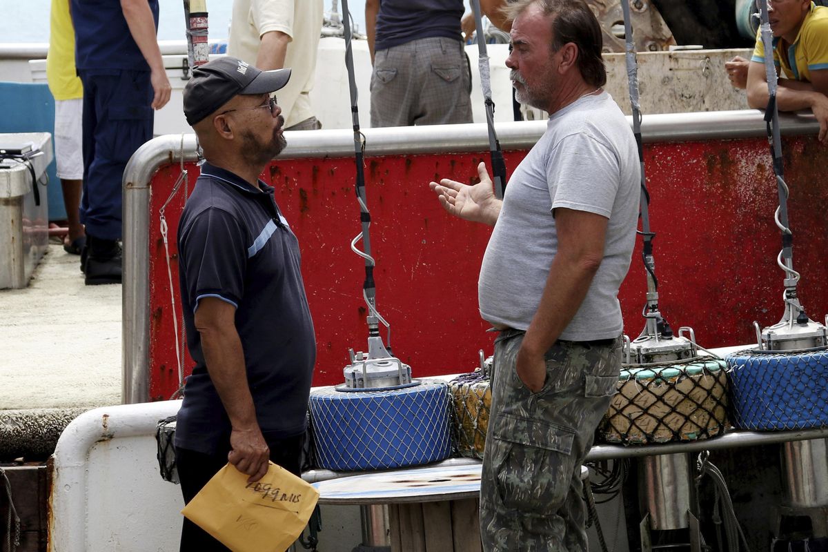 Commercial fishing boat owner Loc Nguyen, left, of Honolulu, talks with the captain of the vessel Princess Hawaii, Robert Nicholson, after he and seven others from the were rescued and returned to Honolulu on Thursday, March 29, 2018. The Princess Hawaii sank off the Big Island on March 25, 2018. All eight people aboard escaped and were rescued by their sister ship, the Commander. (Sophia Yan / Associated Press)