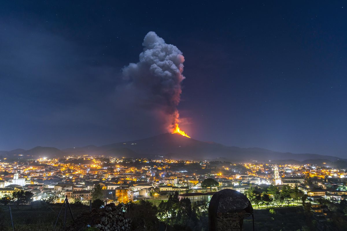Flames and smoke billowing from a crater loom over the city of Pedara, Sicily, on Wednesday.  (Salvatore Allegra)