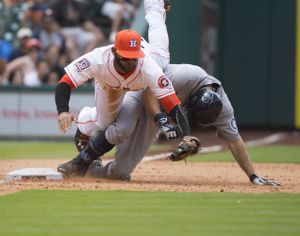 Astros Jonathan Villar flies over Seth Smith going after a bad throw at third base after Smith tripled. Smith scored on the play. (Associated Press)