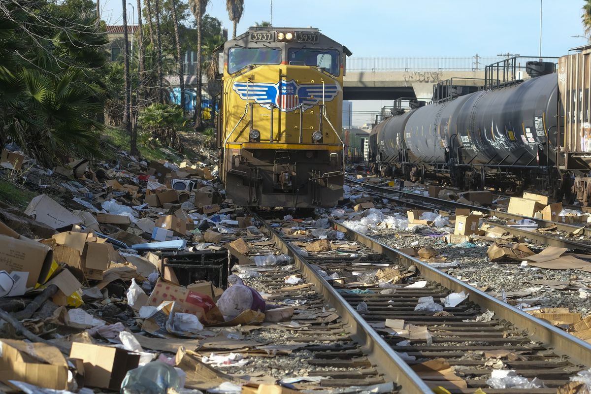 Shredded boxes and packages are seen at a section of the Union Pacific train tracks in downtown Los Angeles Friday, Jan. 14, 2022. Thieves have been raiding cargo containers aboard trains nearing downtown Los Angeles for months, leaving the tracks blanketed with discarded packages. The sea of debris left behind included items that the thieves apparently didn