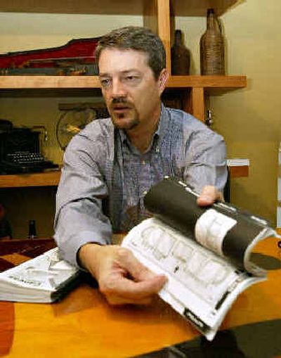 Eddie Hopps thumbs through an instruction manual produced by his Infographics design company in Knoxville, Tenn.
(Associated Press / The Spokesman-Review)