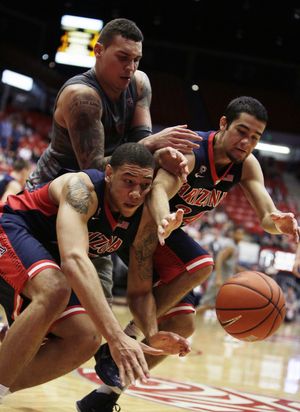 Arizona’s Brandon Ashley, left, and Elliott Pitts, right, go after the ball against Washington State’s Jordan Railey during the second half. (Associated Press)