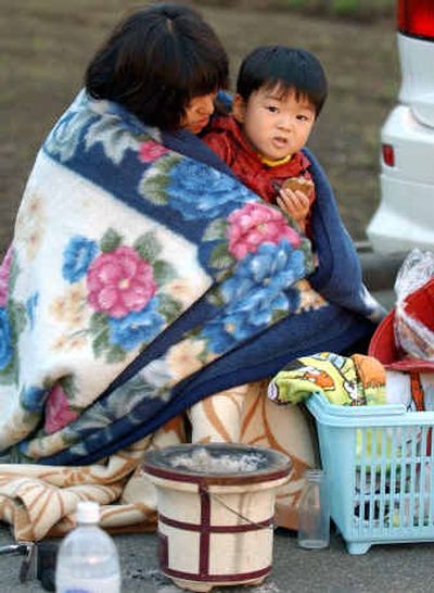 
A mother holds her son in a blanket early this morning after spending the night on a road in Ojiya, northwest of Tokyo.
 (AP photo/Kyodo News / The Spokesman-Review)