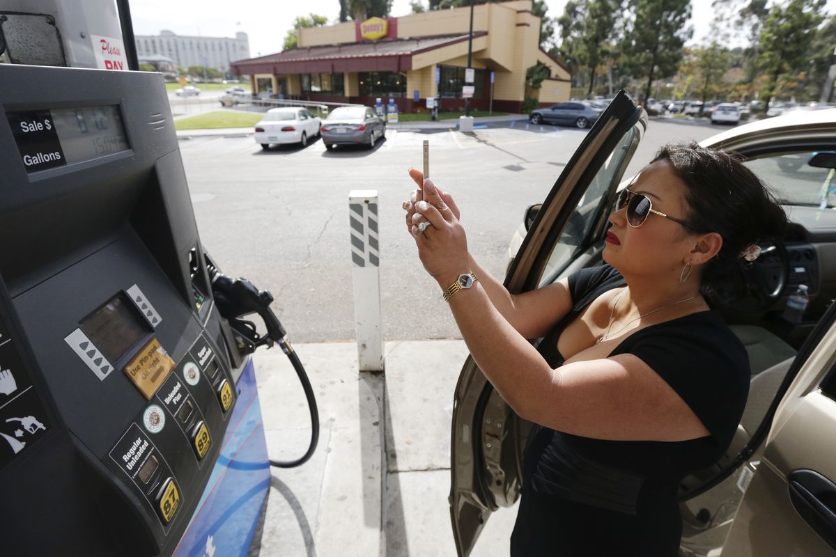 Lorena Delara takes a picture of the total she paid after filling up her tank with gasoline at a gas station Friday, Oct. 5, 2012, in San Diego. Delara paid $81.27 for a little over 15 gallons of gas. A 20-cent jump overnight in California gas prices has put the state ahead of Hawaii for the nation