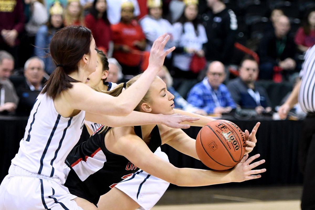 St. Georges guard Cambrie Rickard (in black) tries to keep the control of the ball as Tri-Cities center Emily Dickson reaches in during a State 2b basketball game, Wed., March 4, 2020, in the Spokane Arena. (Colin Mulvany / The Spokesman-Review)