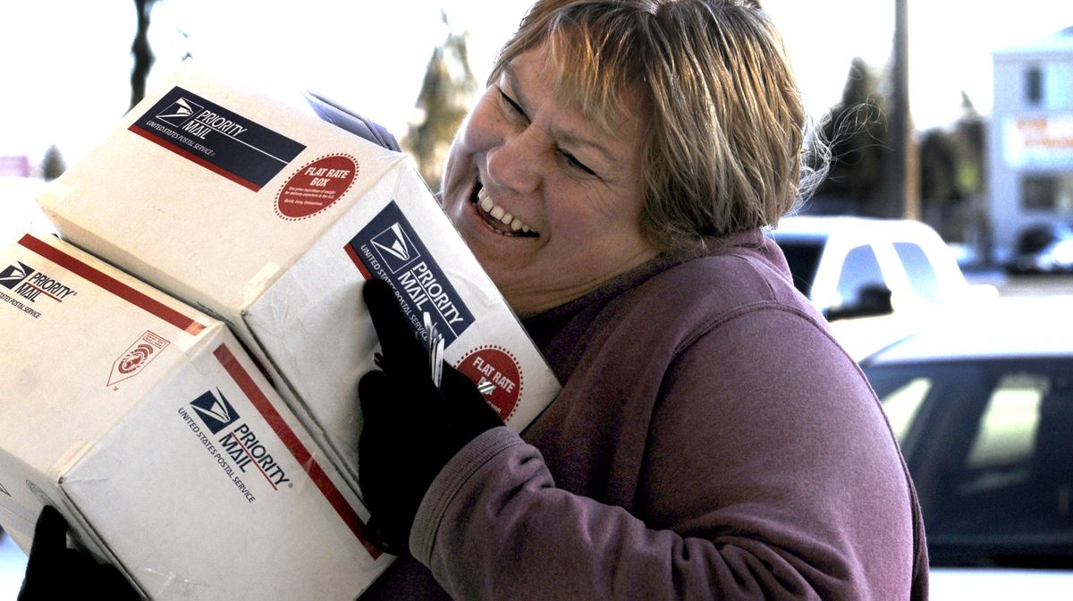 “This is their Black Friday,”  Janine Vichi, of Post Falls, says as she carries her packages into the post office in Post Falls on Monday.  (Photos by KATHY PLONKA / The Spokesman-Review)
