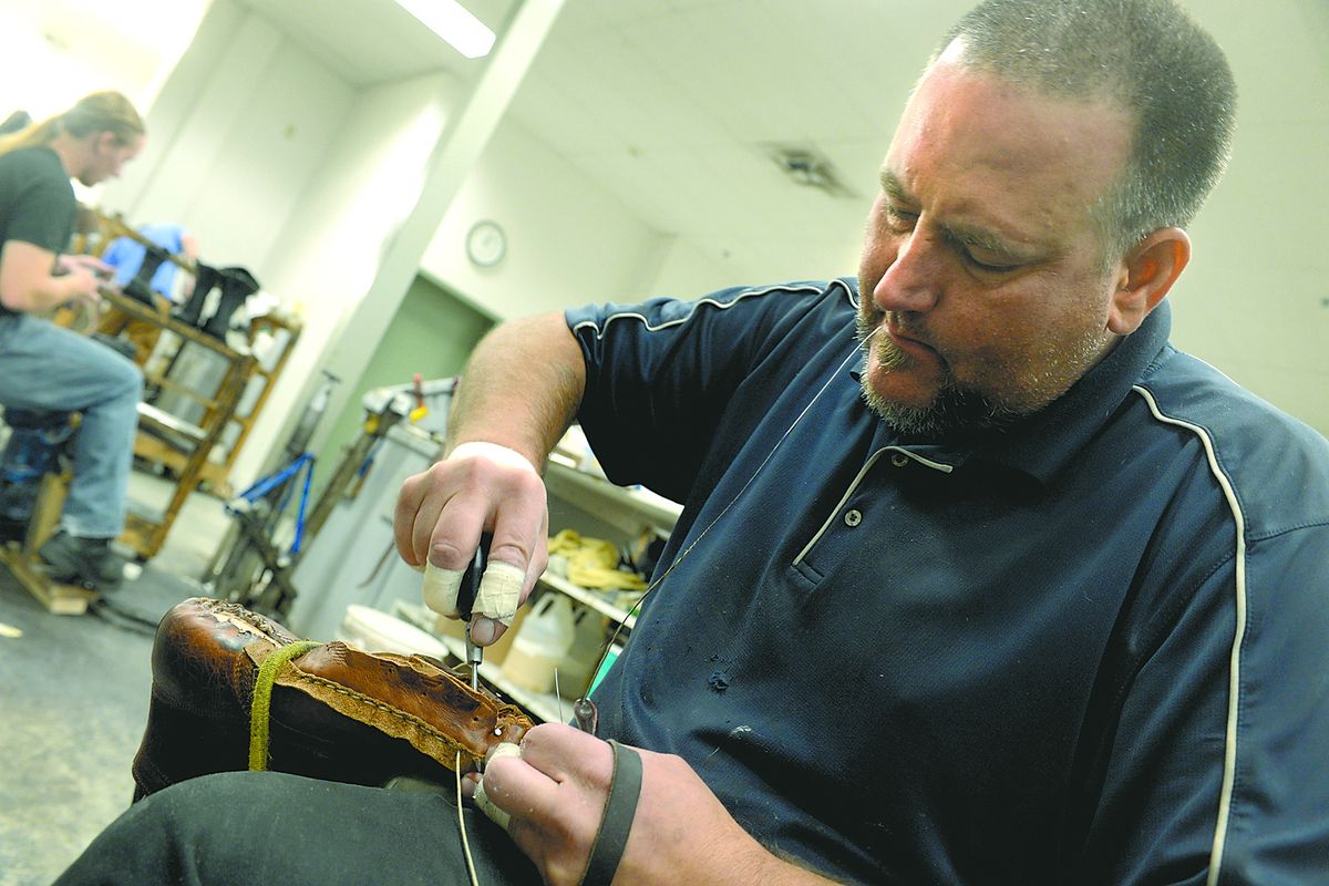 Shoemaker Jeremy Risinger uses a sewing awl and heavy string to assemble work boots at White’s Boots on Wednesday. The company is known for its handmade work boots, but also makes lines of boots that sell for top dollar in Asia. Risinger has worked at White’s for 21 years. (Jesse Tinsley)