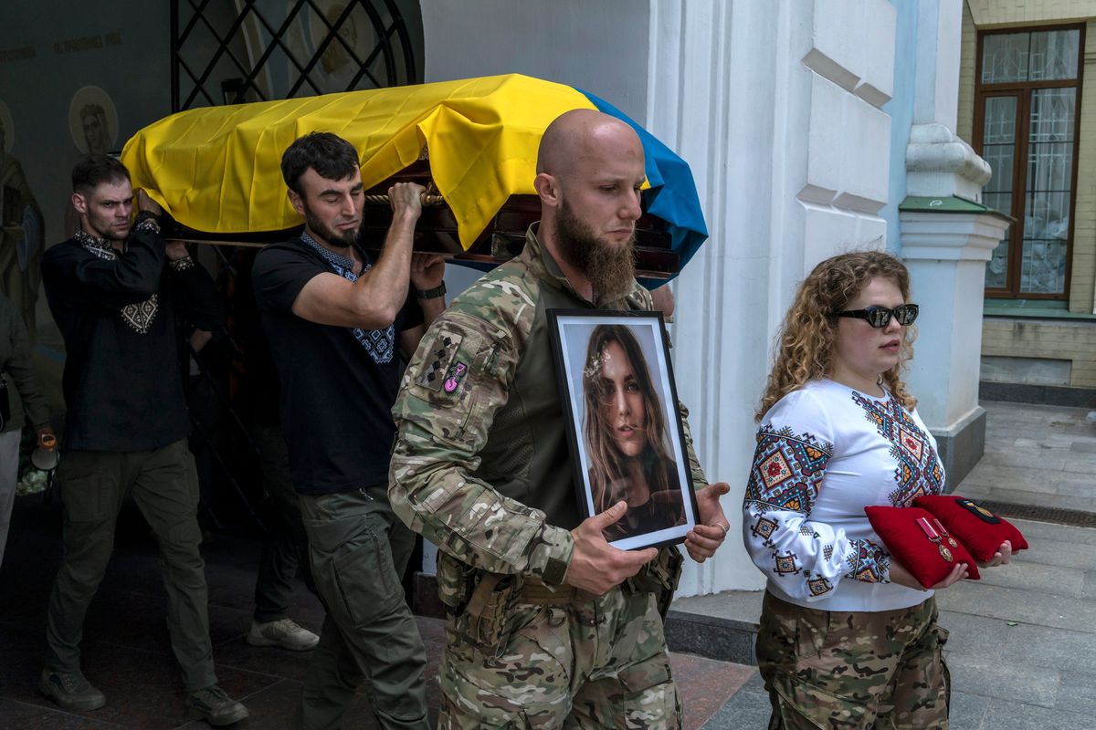 Mourners carry the coffin of Iryna Tsybukh, a Ukrainian combat medic killed on the front line days before her 26th birthday, on June 2 in Kyiv.  (BRENDAN HOFFMAN)