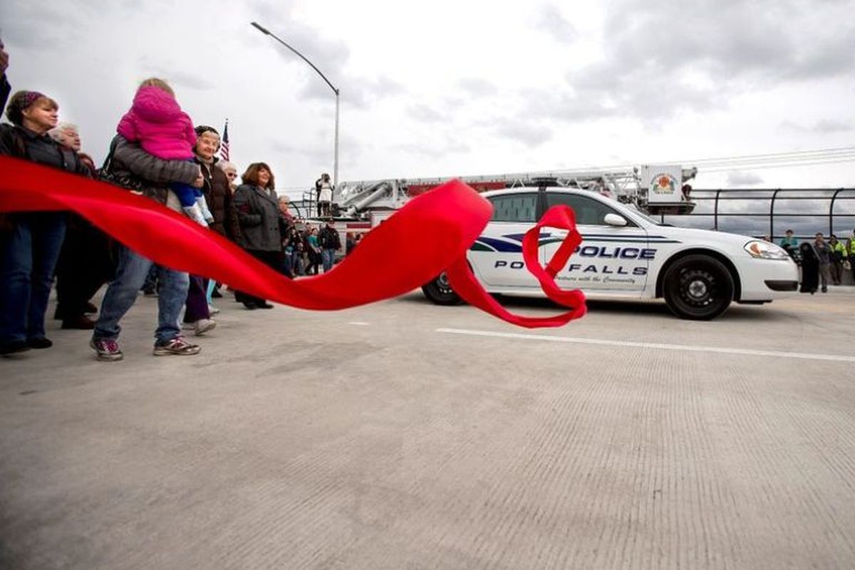 A Post Falls police vehicle "cuts" the ceremonial ribbon to officially open the Greensferry Overpass on Thursday in Post Falls. (Jake Parrish / Coeur d