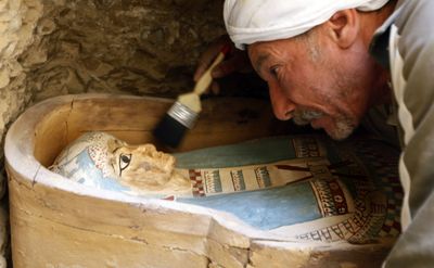 An Egyptian worker brushes the sarcophagus of an Illahun mayor’s daughter (circa 931-725 B.C.) inside a rock-cut tomb. (Associated Press / The Spokesman-Review)