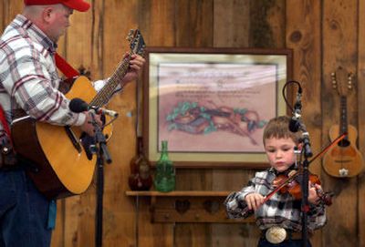 
Seven-year-old Drew Miller, of Otis Orchards, accompanied by his father, Ed Miller, plays during the Northwest Regional Fiddle Contest on Saturday.
 (Photos by Holly Pickett / The Spokesman-Review)