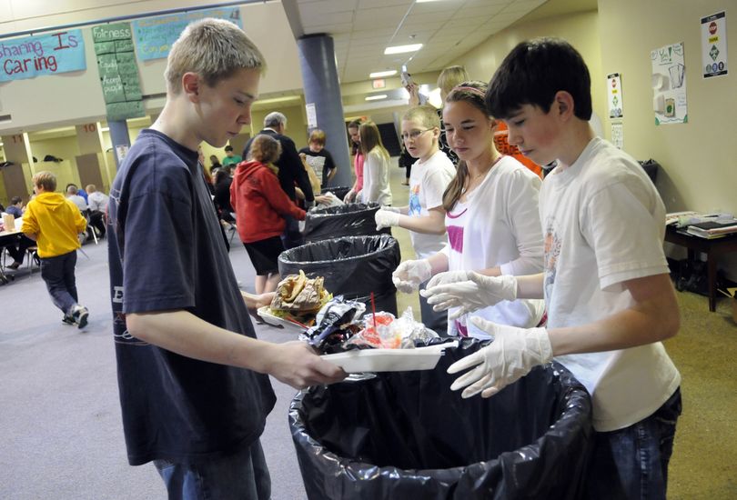 Horizon Middle School eighth-grader Lucas Fitzsimmons, left, gets help separating leftover food waste and soiled paper from garbage, as part of the Central Valley School District’s cafeteria composting program. Assisting him, from right, are eighth-grade leadership students Colby Potts, Emma Kennedy and Scott McKinley. (J. Bart Rayniak)