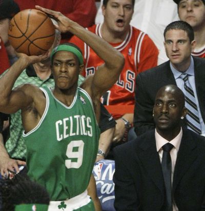Injured Celtic Kevin Garnett, lower right, watches as teammate Rajon Rondo shoots against Chicago. Rondo scored 20 points. (Associated Press / The Spokesman-Review)