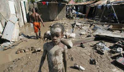 
A little boy is covered in mud as he stands outside of what was once his home in Gonaives, Haiti, Tuesday after floods from Tropical Storm Jeanne swept the town, killing at least 600 people. 
 (Associated Press / The Spokesman-Review)