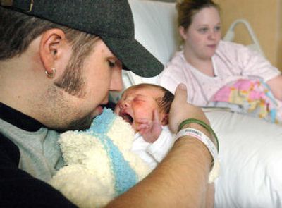 
Bryan Grayhek holds his newborn daughter, Georgia Leigh Grayheck, as his wife Audrey rests Thursday at Sacred Heart Medical Center. The couple's first child, Georgia was named after 