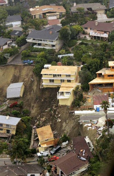
Damaged homes sit on a hillside after a landslide in Laguna Beach, Calif., early Wednesday. The landslide sent multimillion-dollar homes crashing down a hill and injured several people.
 (Associated Press / The Spokesman-Review)