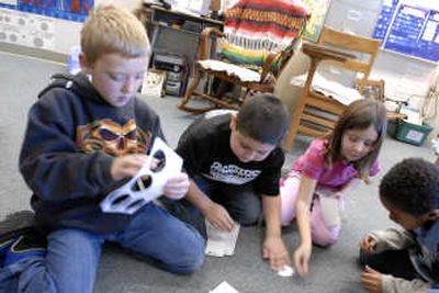 
University Elementary second-graders Dylan Carr, Julio Martinez, Emily Coleman and Marqese Johnson work on the assembly line of the 