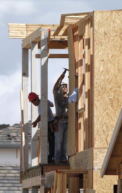 A construction worker hammers on particleboard on a home under construction in Sacramento, Calif., earlier this month. Housing construction posted a modest increase in March while applications for building permits hit their highest level in 18 months.  (Associated Press)